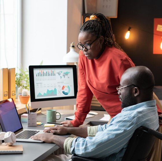 A diverse team of digital strategists gathering around a large, glowing interactive touch-table displaying website user behavior heatmaps, conversion data analytics, and user flow charts in a modern, dark-themed studio with user journey whiteboards in the background.