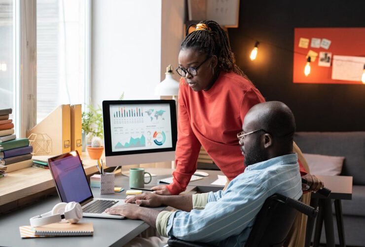 A diverse team of digital strategists gathering around a large, glowing interactive touch-table displaying website user behavior heatmaps, conversion data analytics, and user flow charts in a modern, dark-themed studio with user journey whiteboards in the background.