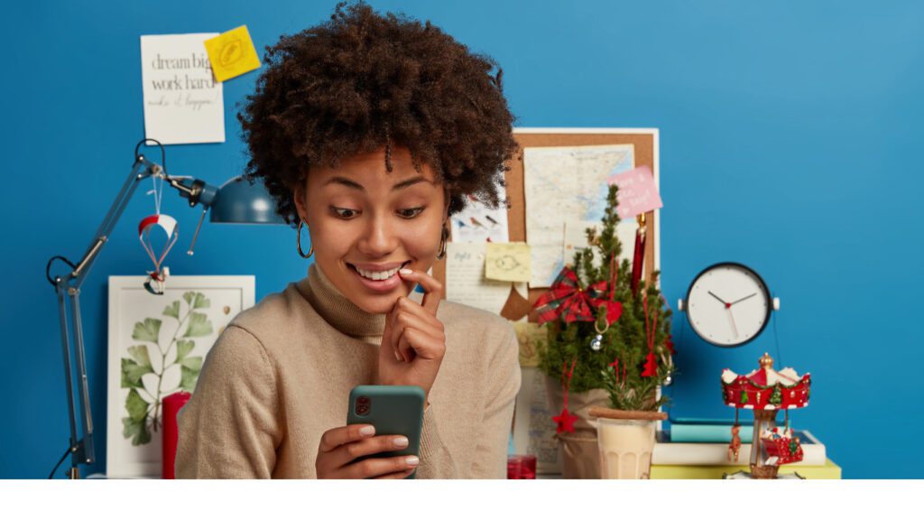 Woman biting her nail while anxiously checking her phone, symbolizing the uncertainty brands face when navigating influencer marketing risks in Nigeria