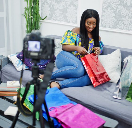 Influencer Marketing in Nigeria: A Strategic Guide to Avoiding Costly Pitfalls 1 Nigerian content creator filming an unboxing video with gift bags for a brand collaboration, illustrating the influencer marketing partnerships brands must vet carefully to avoid costly mistakes