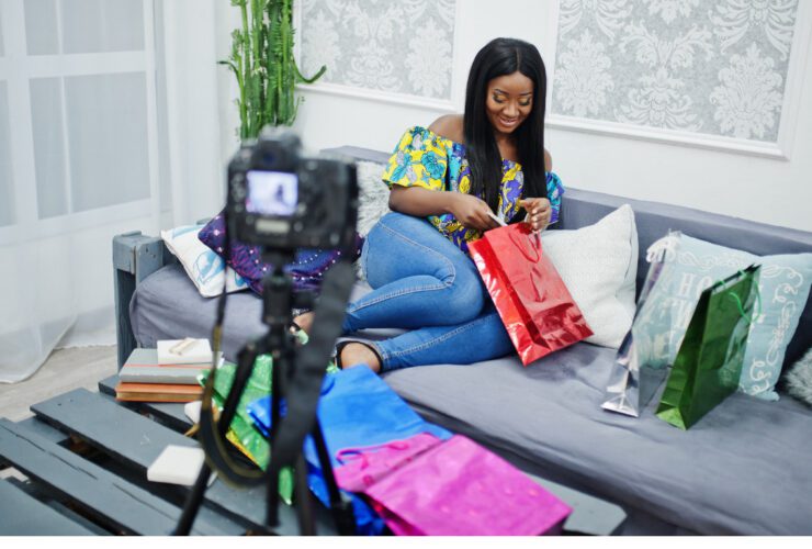 Nigerian content creator filming an unboxing video with gift bags for a brand collaboration, illustrating the influencer marketing partnerships brands must vet carefully to avoid costly mistakes