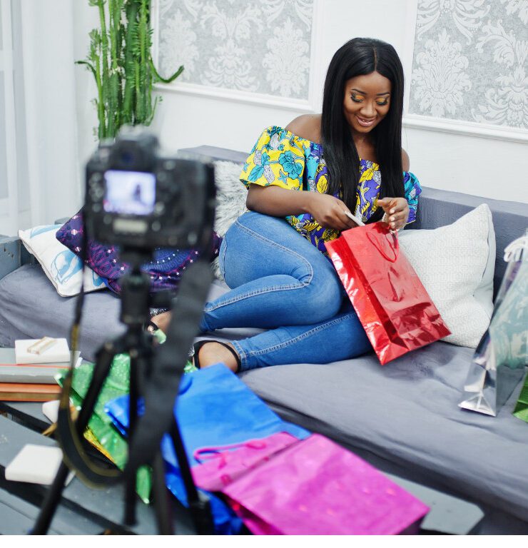 Nigerian content creator filming an unboxing video with gift bags for a brand collaboration, illustrating the influencer marketing partnerships brands must vet carefully to avoid costly mistakes