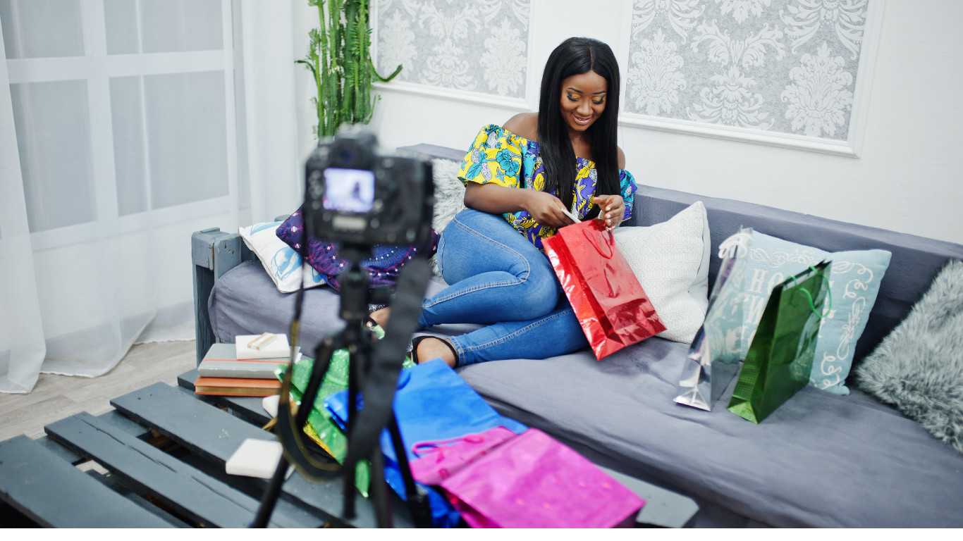Nigerian content creator filming an unboxing video with gift bags for a brand collaboration, illustrating the influencer marketing partnerships brands must vet carefully to avoid costly mistakes