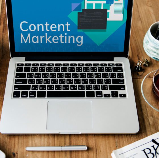 A laptop with 'Content Marketing' on screen at a desk workspace, illustrating content strategy