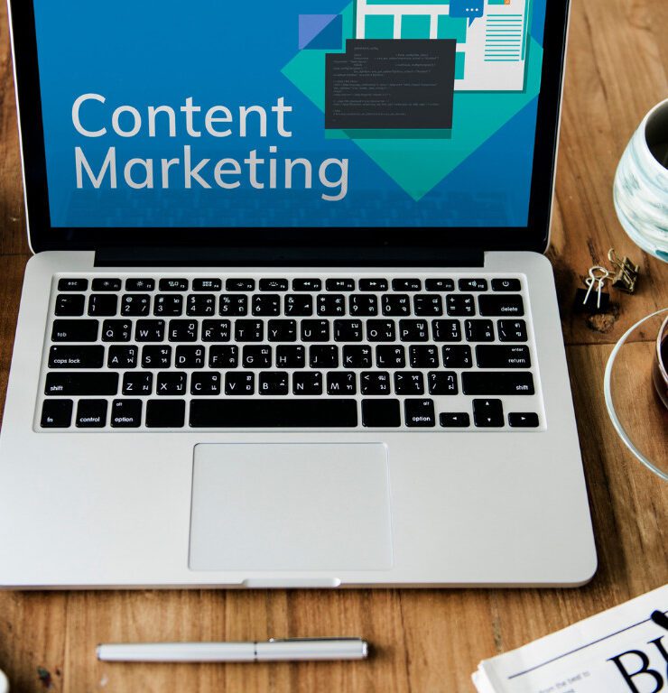 A laptop with 'Content Marketing' on screen at a desk workspace, illustrating content strategy