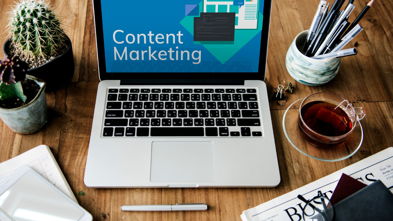 A laptop with 'Content Marketing' on screen at a desk workspace, illustrating content strategy